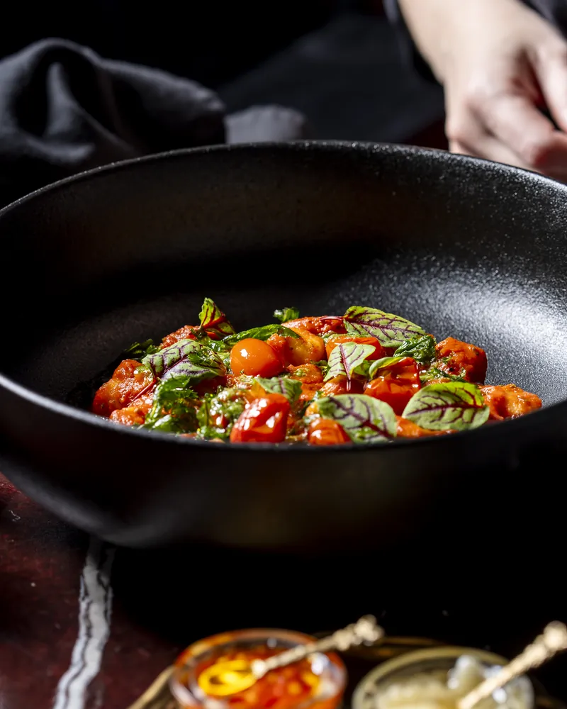 Tomatoes and basil in a black pan